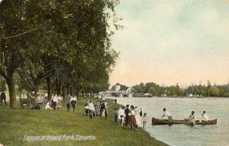 Picture of a lagoon with three people in a canoe and several groups of people on grass with lar…