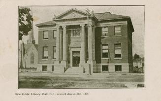 Picture of two story library with large front pillars and church building with spire to the lef…