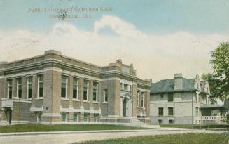 Picture of a street scene with large public library and left and large club house on right. 