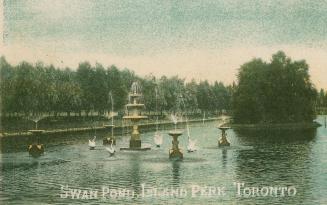 Pond with large fountain and surrounded by trees. 