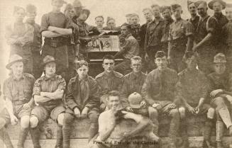 Sepia tones picture of a group of airmen grouped around an upright piano.