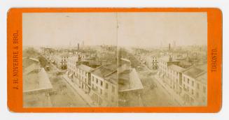 Pictures show a wide street with houses and large building on either side of it.