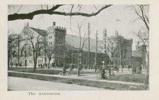 A photograph of a large building in a Romanesque revival architectural style, with turrets on t…