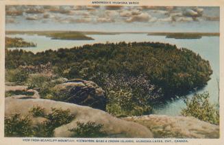 Long range view of a wooded, rocky hill inside a large lake.