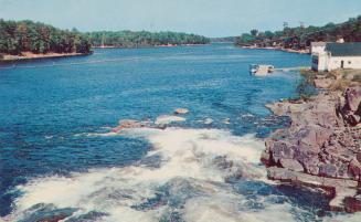 Color photograph of a lake with a rocky shoreline.