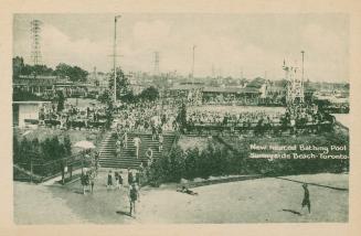 Distant view of large swimming pool and crowds of swimmers with beach and stairs to pool in for…