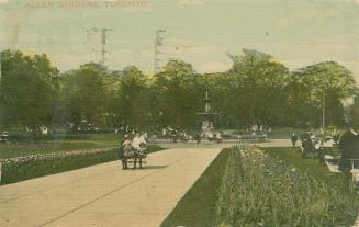 People on pathways in a garden with a large fountain in the center.