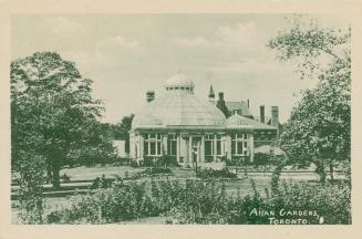 Black and white picture of a large domed building in a city garden.