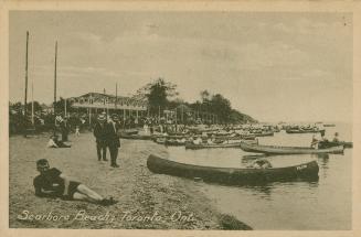 Picture of man lying on the beach in foreground with other people on the beach in background an…