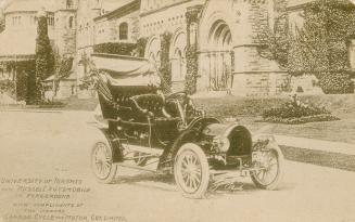 Car on a roadway in front of trees and a large collegiate building. Sepia toned.