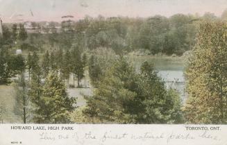 Long shot of a lake in a wooded area.