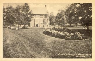 Picture of a park with flower beds and trees and public library in background. 