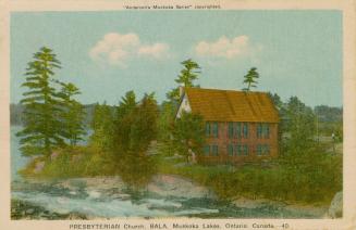 A stone, country church in a wooded area beside a river.