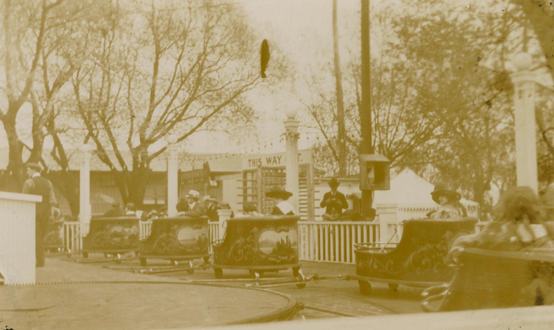 Picture of people on an amusement ride on a track. 