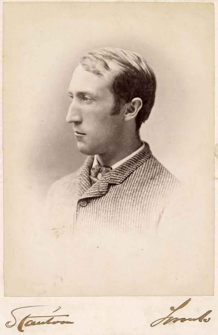 A cabinet card photograph of a middle-aged man, posed in a photography studio and visible from …