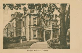 Black and white picture of the front of a large, three story house in a Victorian style.