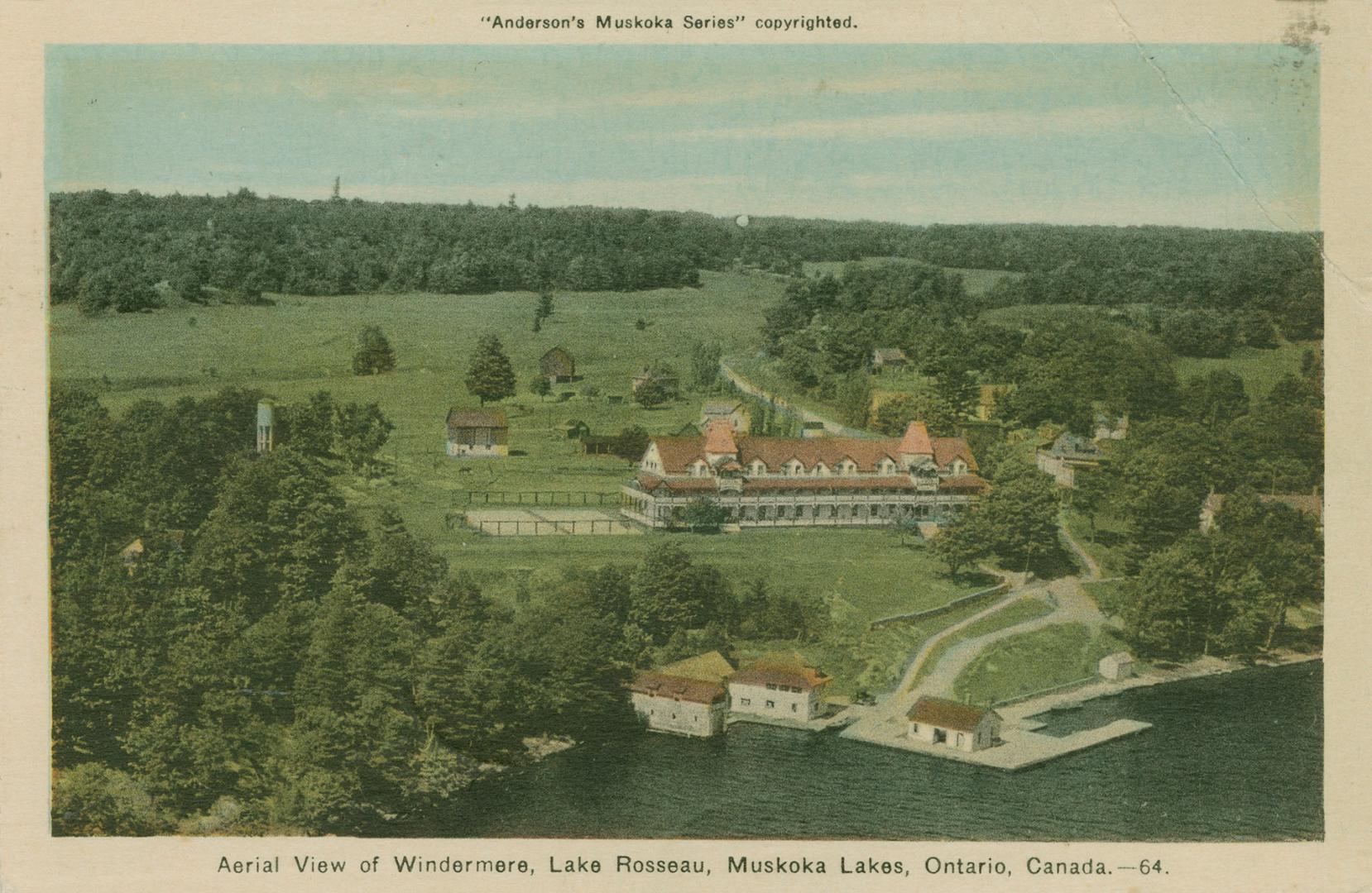 Shot from the air, a large hotel complex on a lake in the wilderness.