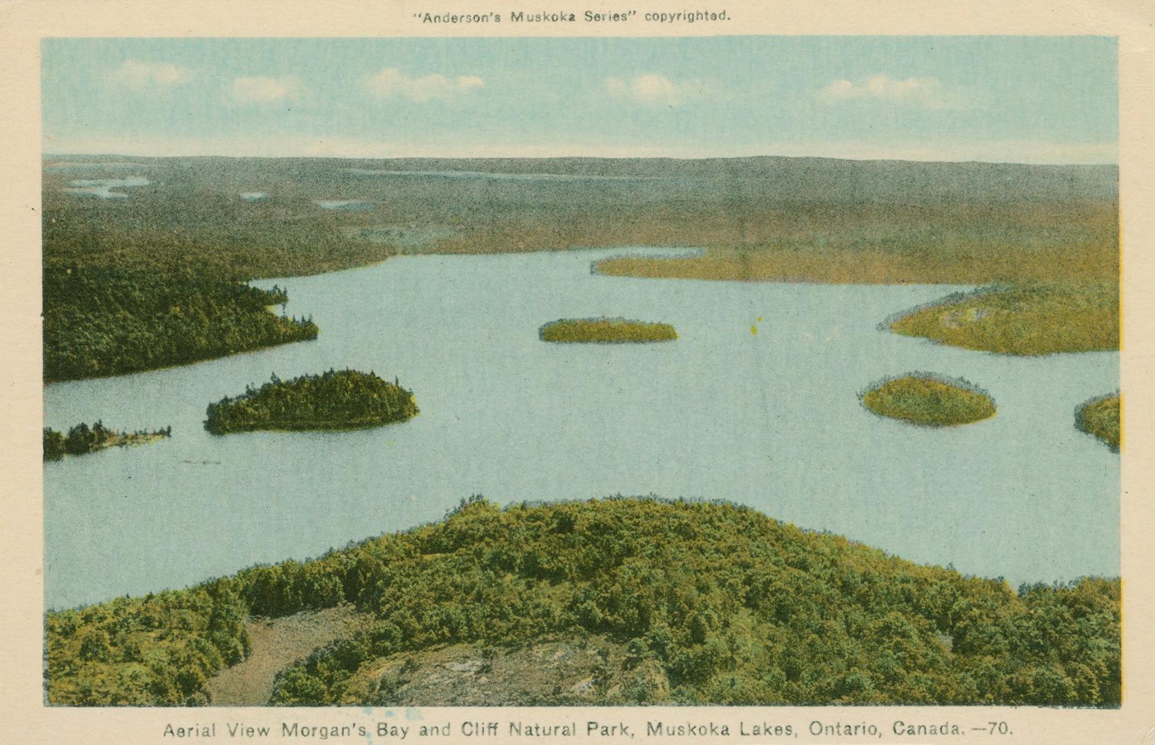 Shot from the air, a large hotel complex on a lake in the wilderness.