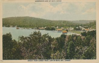 Log shot of cottages on a lake in the wilderness.