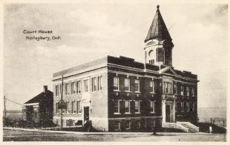 Picture of a three story government building with a central tower.