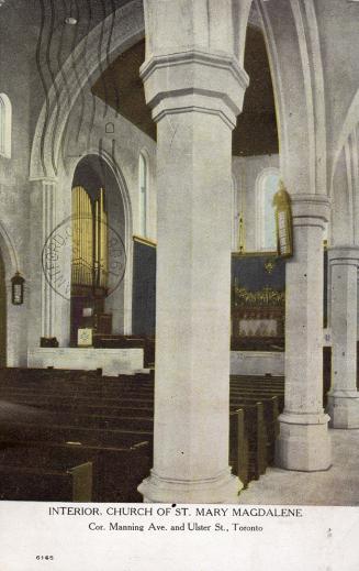 Interior of church with large stone pillars, rows of pews and organ. 