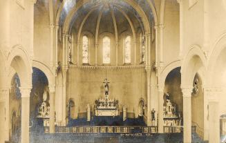 Church interior with arches, chancel and stained glass windows. 