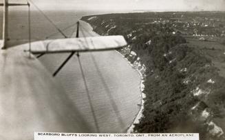 Black and white shot of an air plane flying across a field from the perspective of the wings.