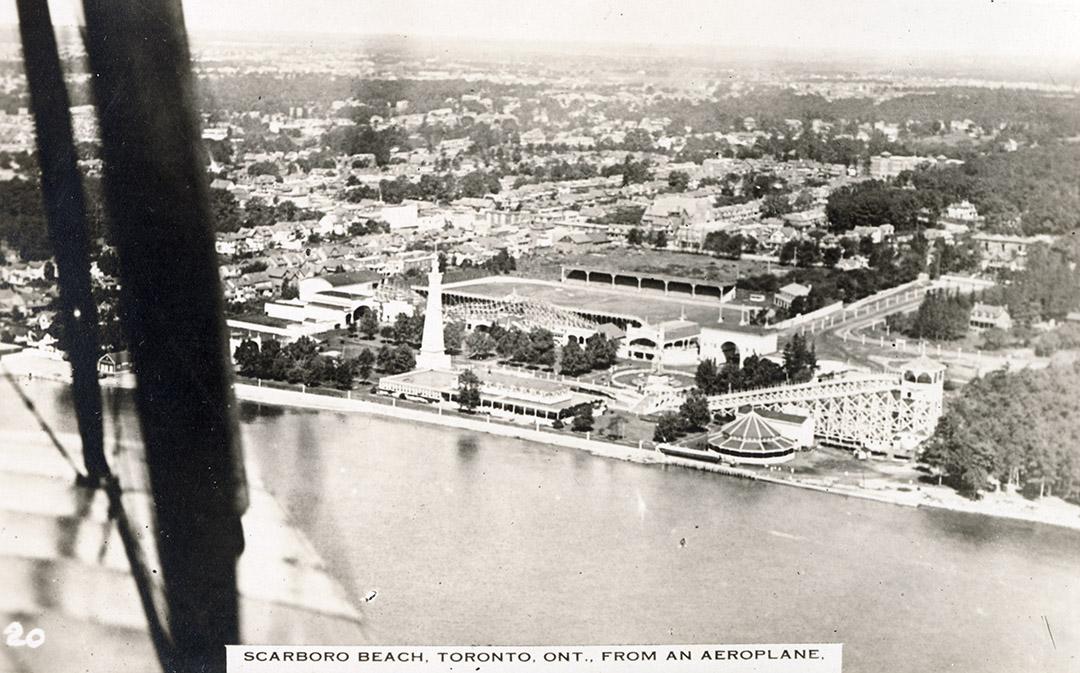 Black and white aerial shot of an amusement park on the edge of a lake. B & W.