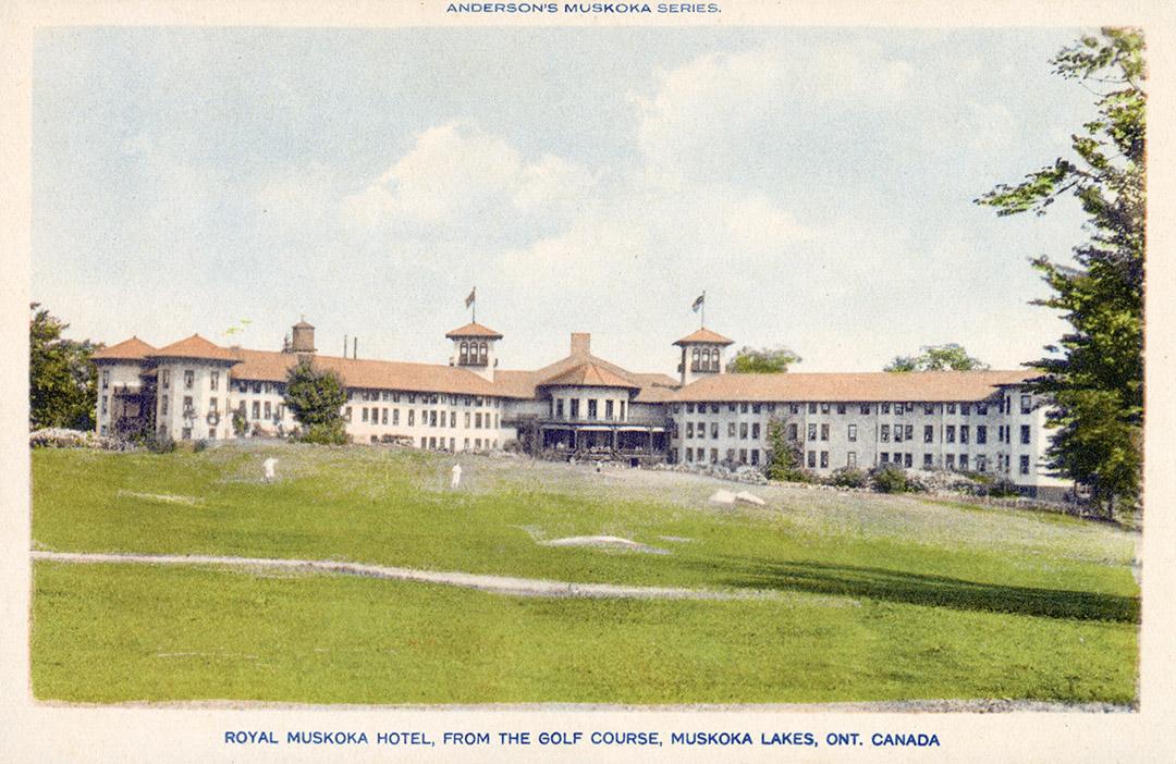 A large hotel complex in an "L: shape with a gold course in front of it.