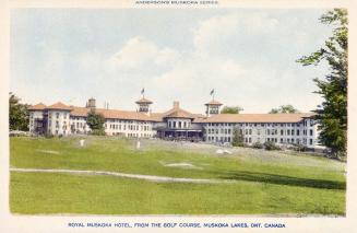 A large hotel complex in an "L: shape with a gold course in front of it.