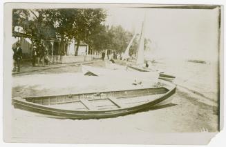 Black and white photograph picture of a crowded beach beside a body of water.