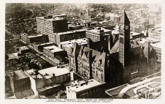 Aerial shot of a large city with tall buildings and a Richardsonian Romanesque structure in the…