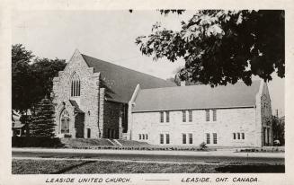 Picture of large stone church buildings surrounded by lawn and trees. 