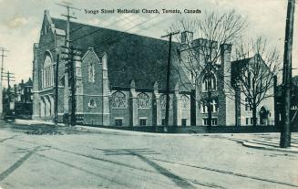 Picture of large stone church on street corner. 