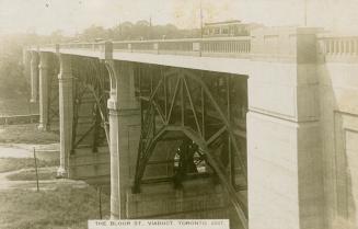 Black and white photograph of a large bridge spanning a valley.