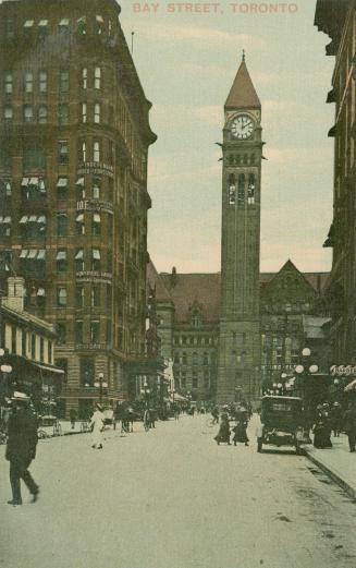 Colorized photograph of a busy city street with a large public building with a clock tower at t…