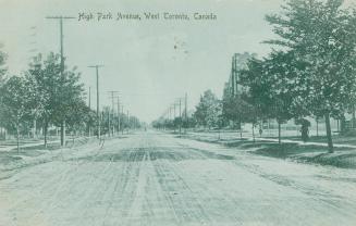 Picture of wide dirt street with some trees and a church. 