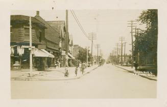 Picture of street corner and shops on one side. 