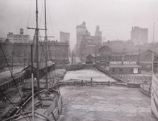 Image shows a wharf view with some buildings in the background.