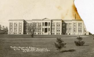 Black and white photograph of a large, three story hospital building.