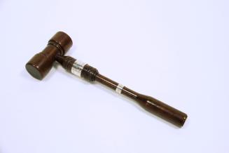 A small gavel made of dark wood.