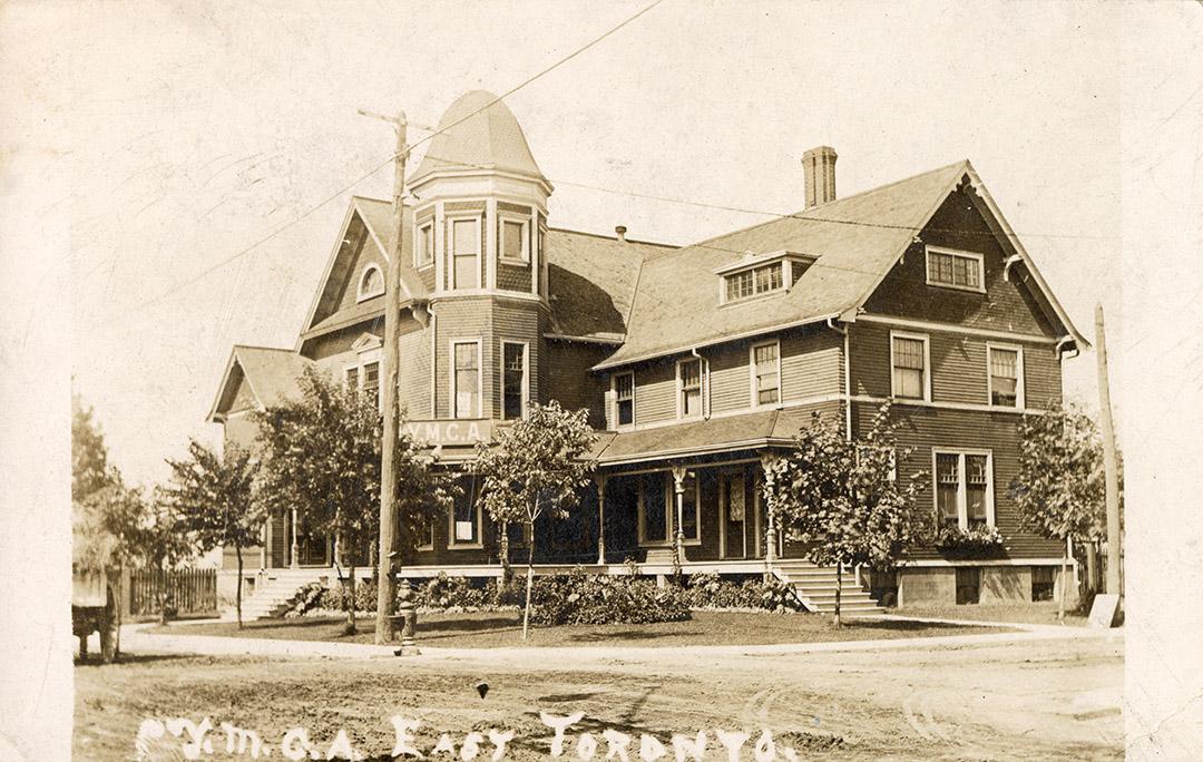 Black and white photograph of a large, three story frame house.