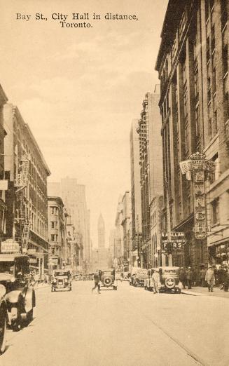 Sepia toned picture of a busy city street with multi-story building on either side of it; autom…