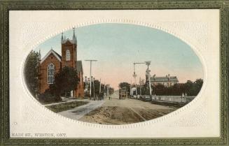 Colorized photograph of a city street in a residential area. Oval set inside a white frame.