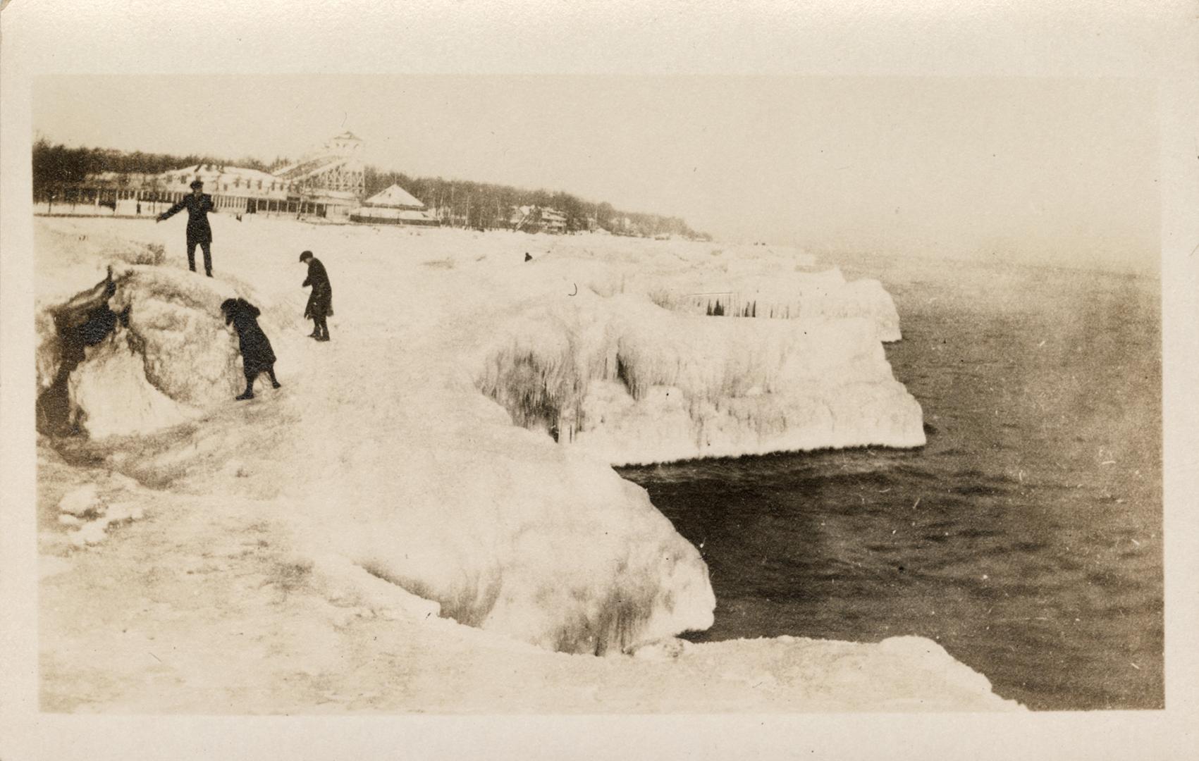 Picture of ice formations on the beach and houses in the background. 