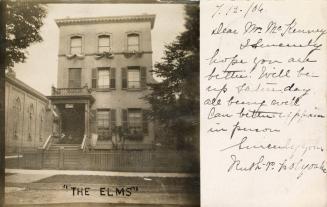 Black and white picture of small, three story hotel.