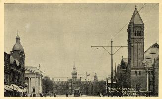 Black and white picture of a city street scene with a gothic style building at the end of it.