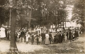 Group of people in a park watching a sporting event. 