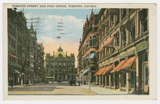 Colorized photograph of a city street with tall building on either side. Large, Second Empire s…