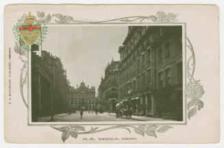 Black and white photograph of a city street with tall building on either side. Large, Second Em…